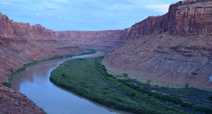 A river winds through red canyon walls at dusk